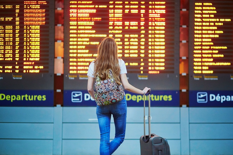 airport layover woman looking at departures board